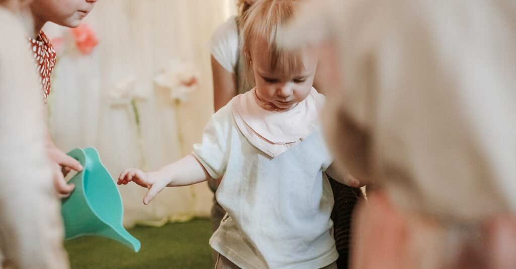 保育園で職員がトランポリンを見守る様子。複数職員が配置され、死角をなくして園児の安全を確保している環境。