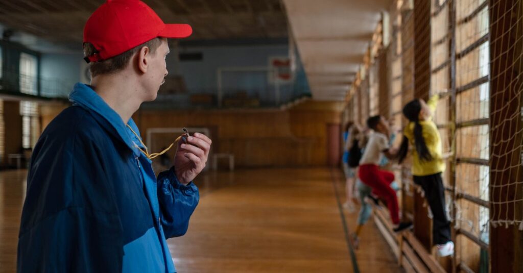スポーツクラブでトランポリンを教えるコーチと子どもの指導風景